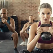 Frau beim Kettlebell-Training im Fitnessstudio